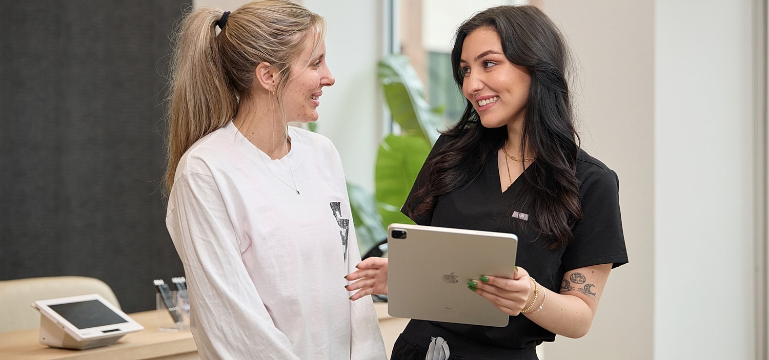 Two women discussing using a tablet.