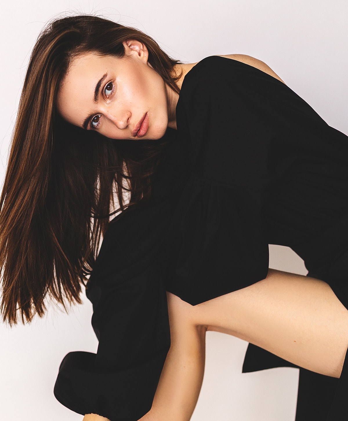 Woman posing elegantly in black outfit.