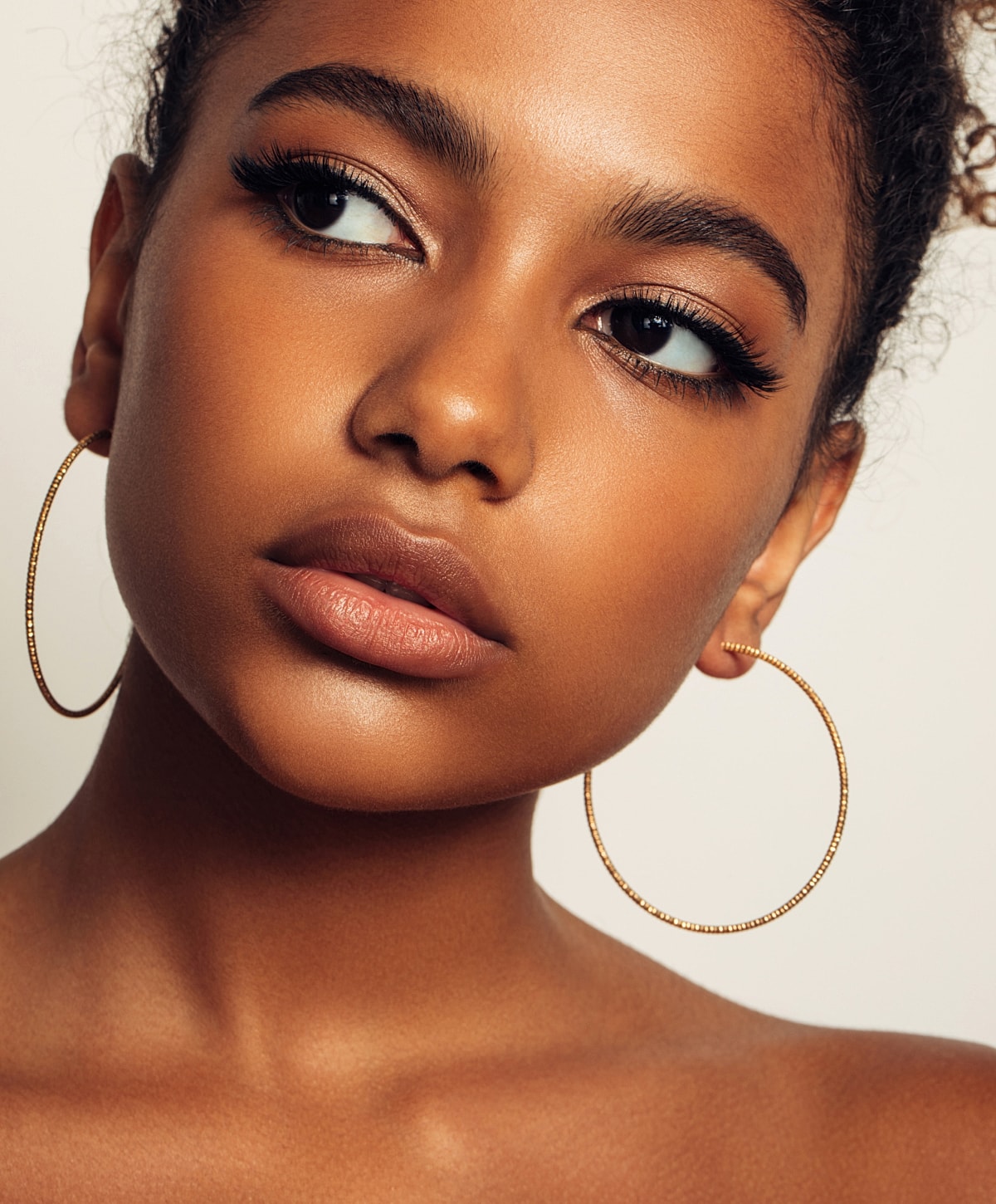 Close-up of young woman with hoop earrings.