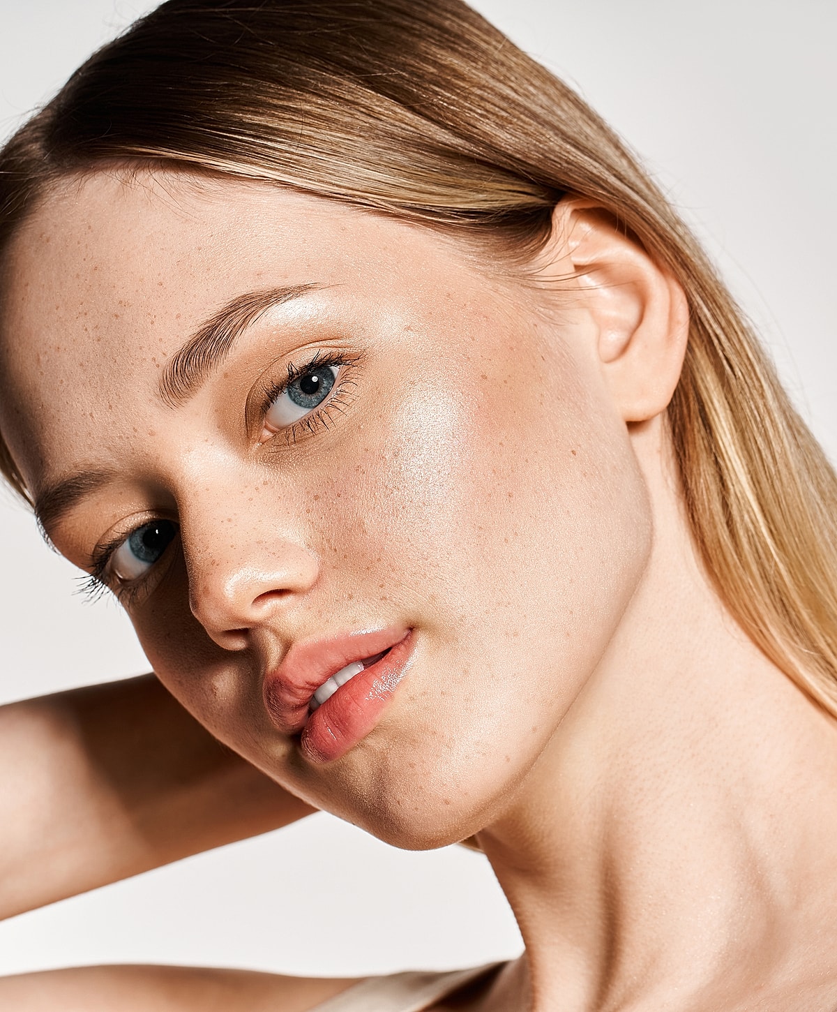 Close-up of model with glowing skin and freckles.
