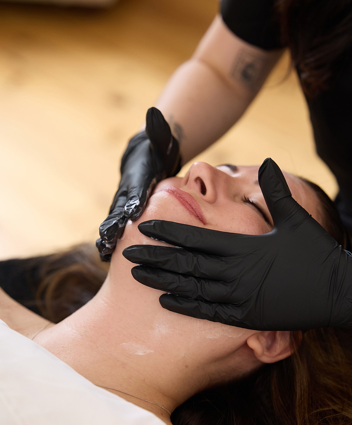 Facial treatment with gloved hands.