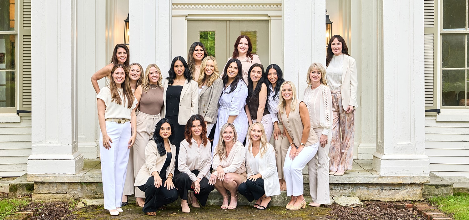 Group of women posing outside a stylish building.