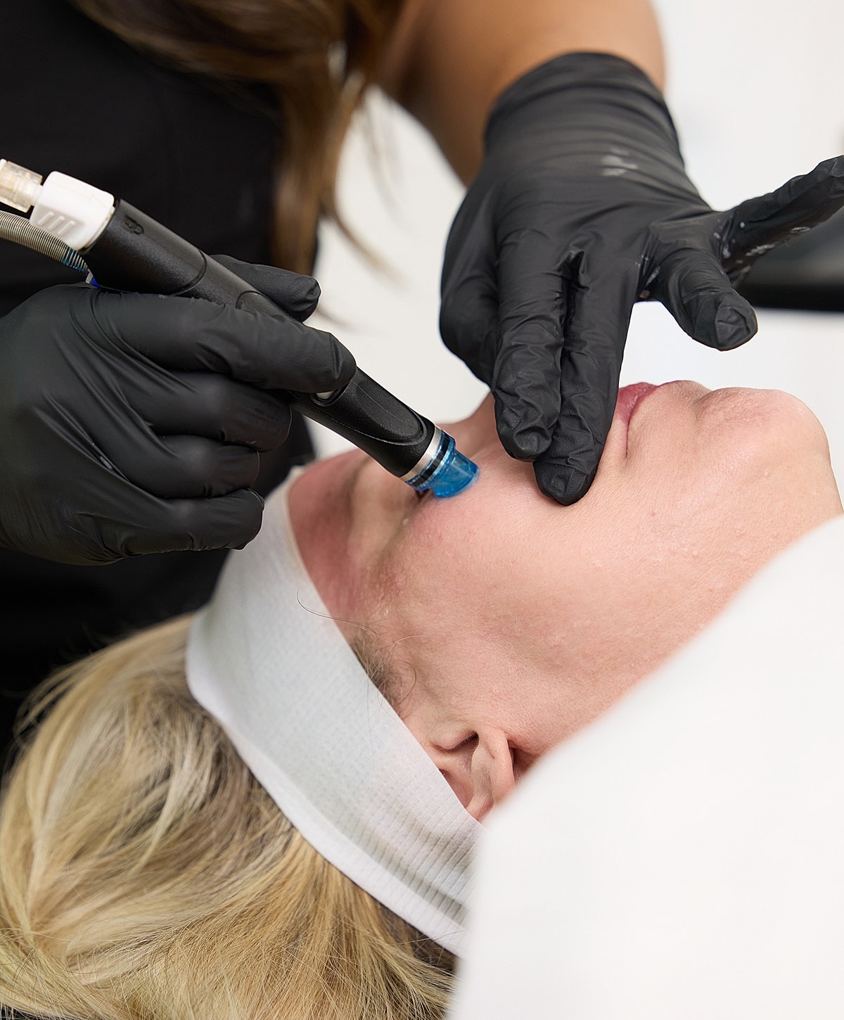 Facial treatment with microdermabrasion device and gloves.