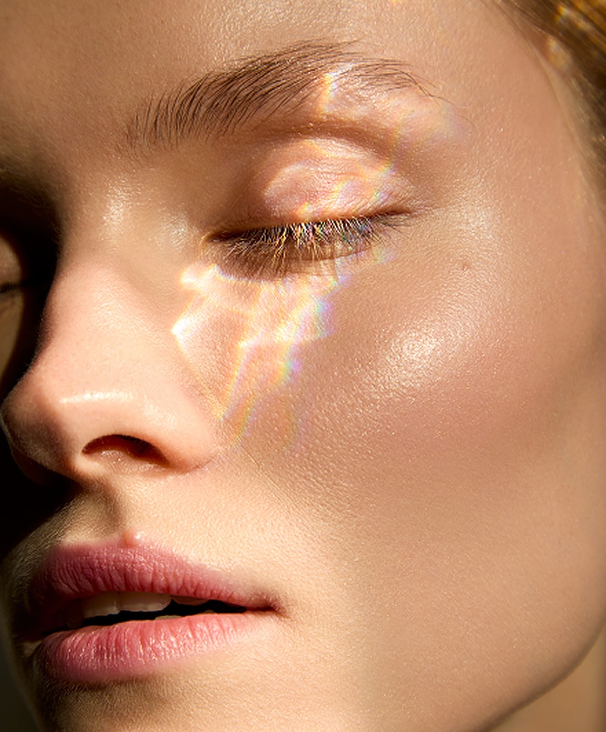 Close-up of model with glowing skin and freckles.