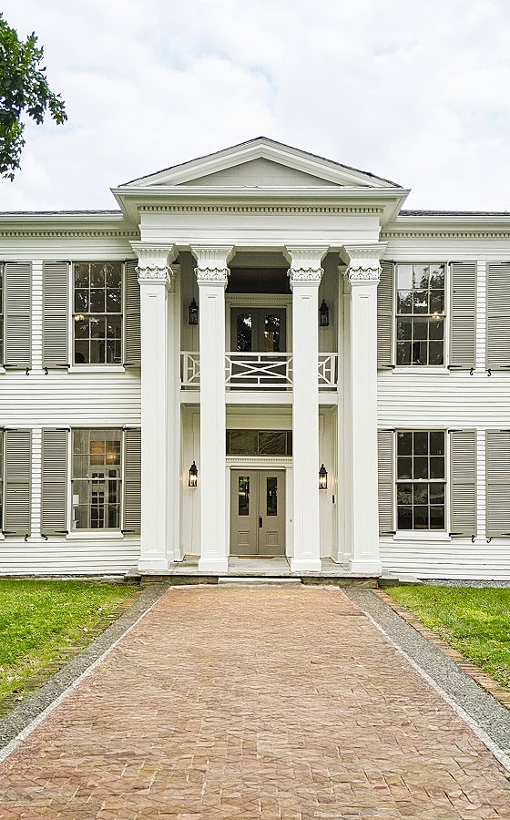 Historic white mansion with columns and windows.