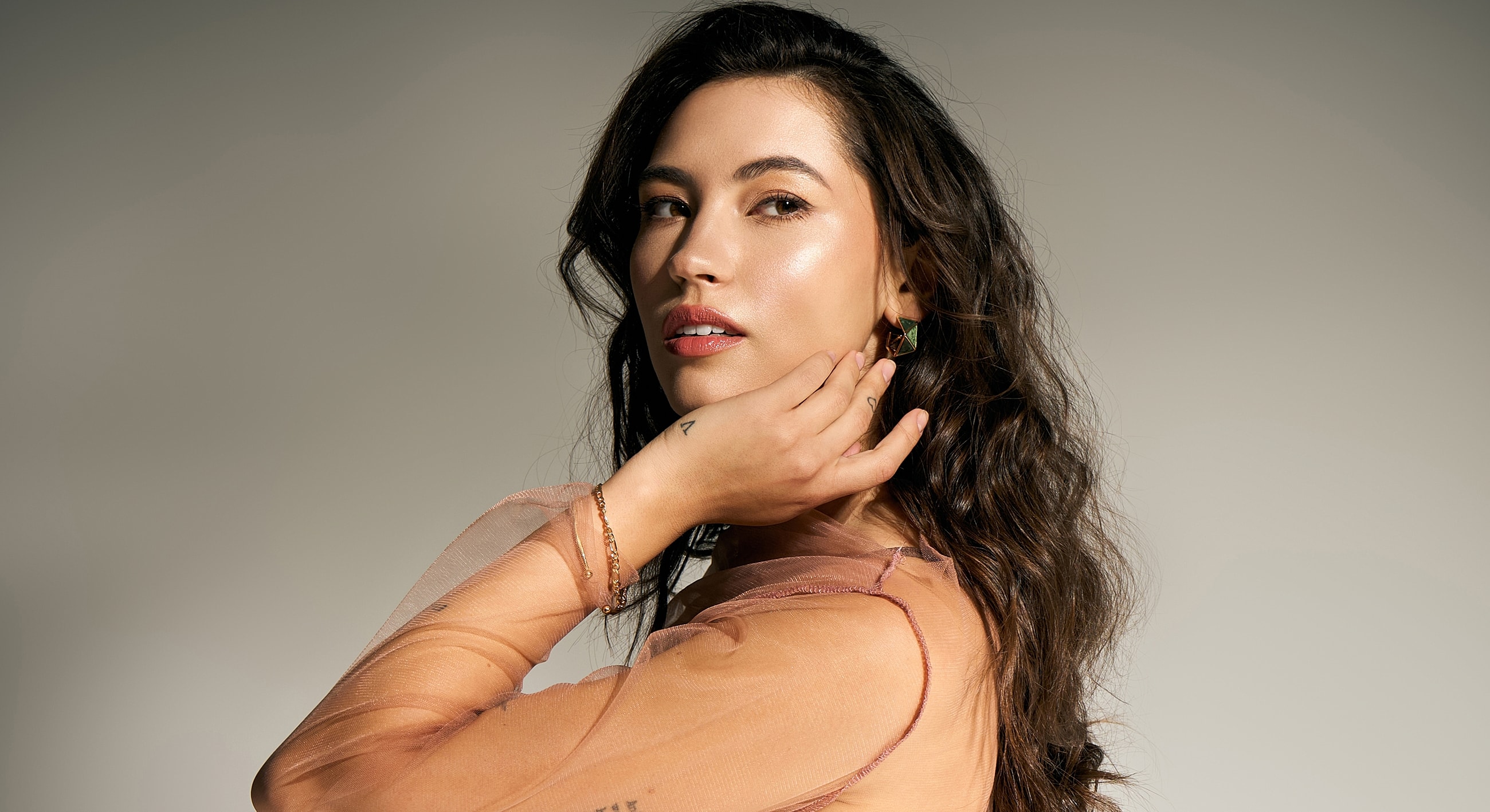 Woman with curly hair in elegant pose.