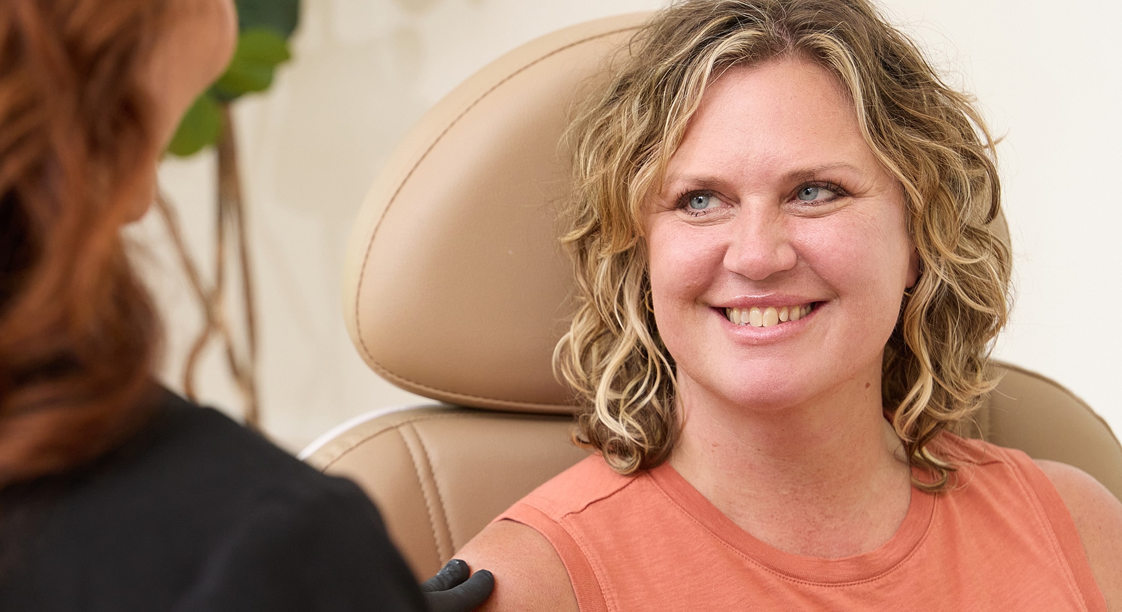 Woman smiling in a medical consultation setting.
