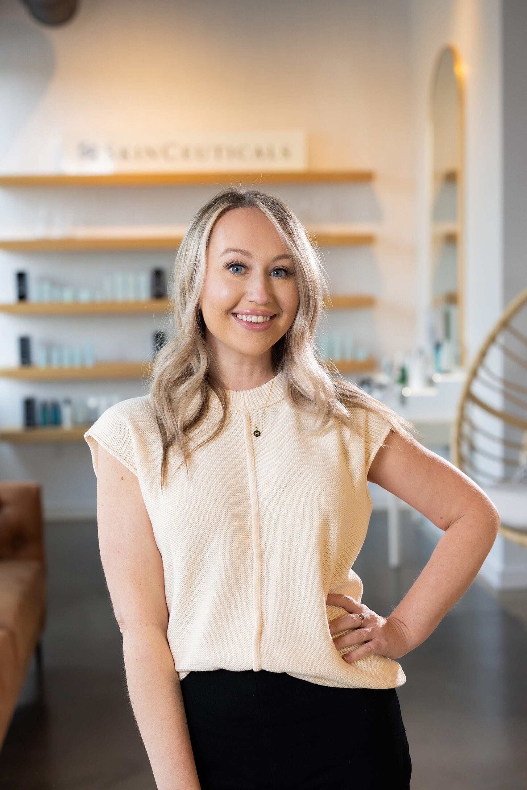 Smiling woman standing in a modern skincare studio.