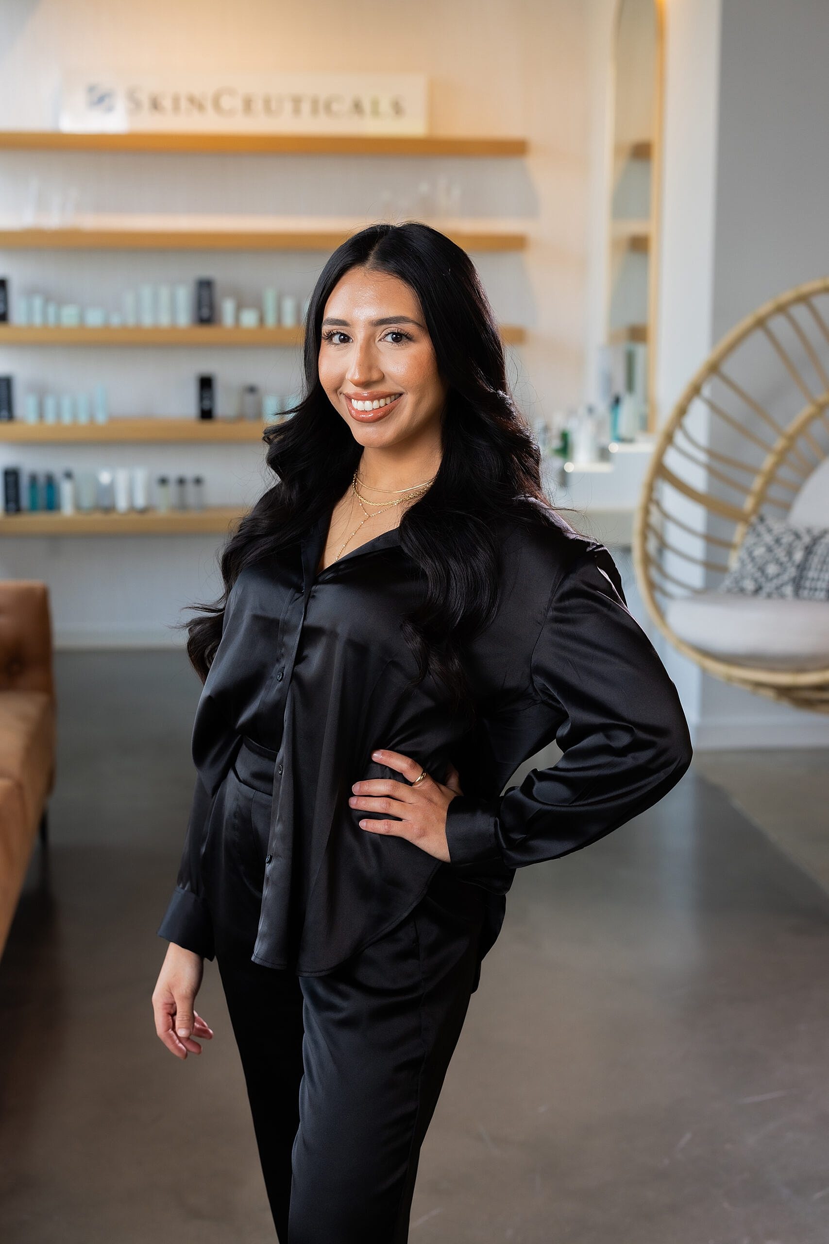 Woman in black outfit smiling indoors.