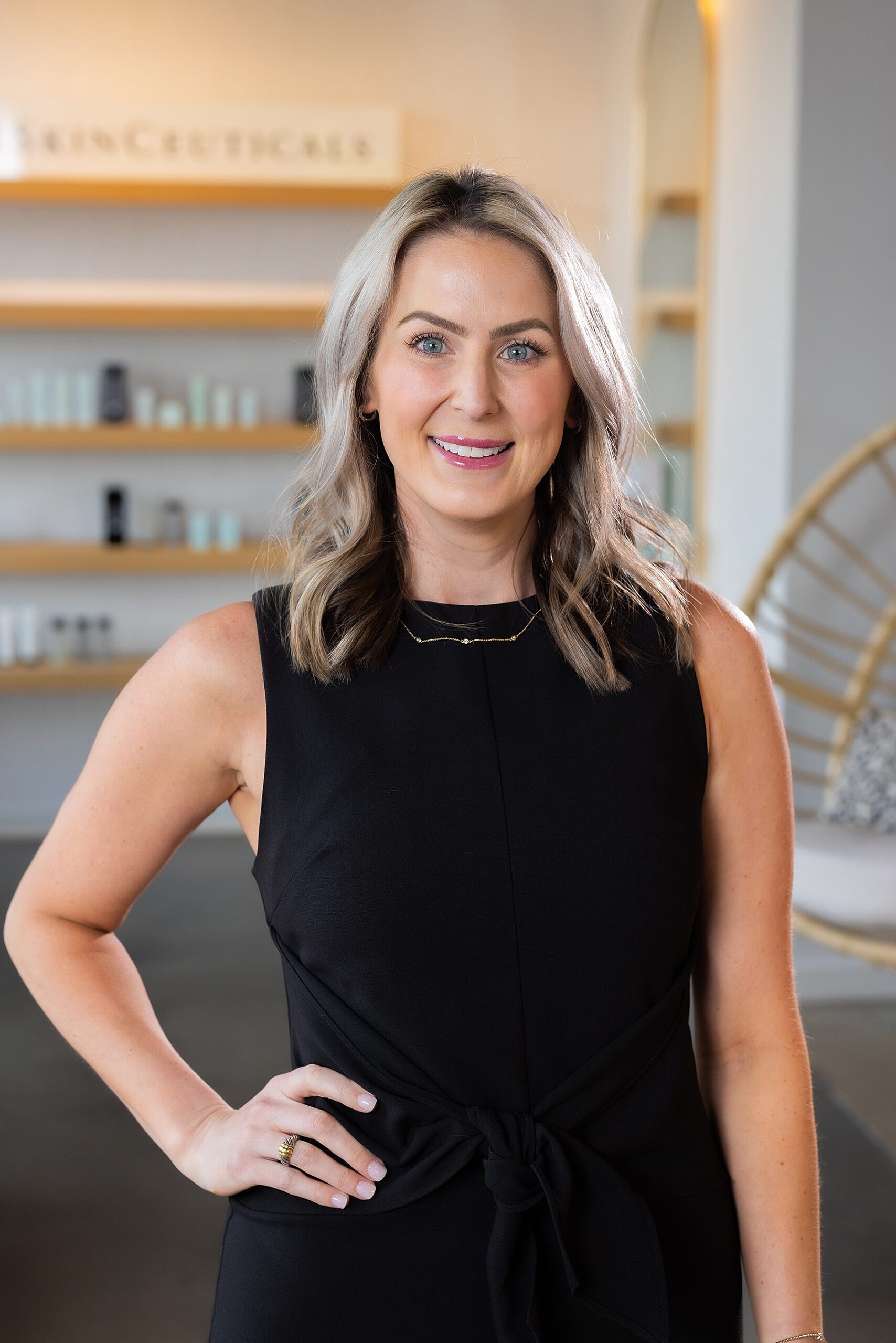 Smiling woman in black outfit with a nice background.