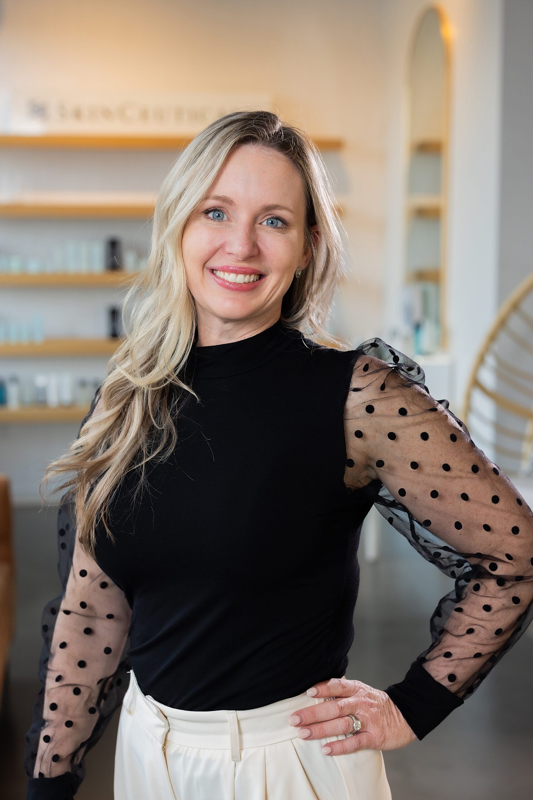 Smiling woman in stylish polka dot sweater.